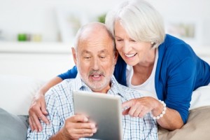 lachendes senioren-paar mit tablet