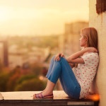 beautiful blonde sitting on the roof of the house