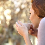 Relaxed woman holding a cup of coffee outdoor